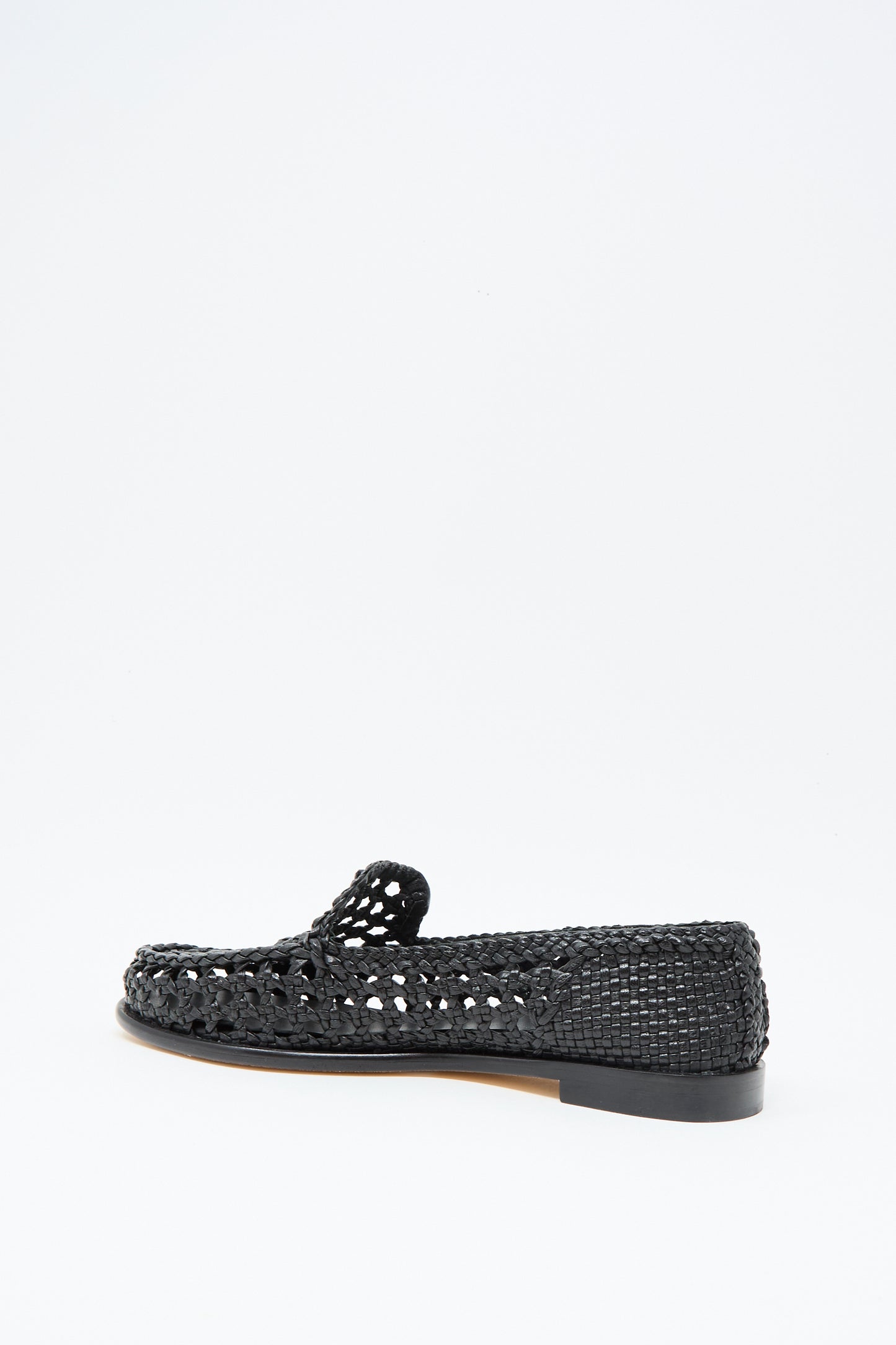 The Dolly Moccasin in Black by Dragon Diffusion is a chic black woven leather loafer with a low heel and airy, partially open design, shown against a plain white background.