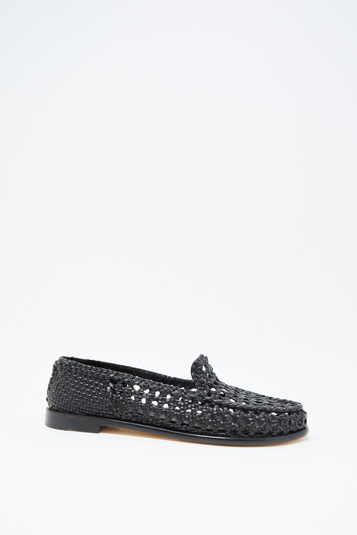 The Dolly Moccasin in Black by Dragon Diffusion is a black woven leather loafer with a low heel and closed toe, shown on a plain white background.
