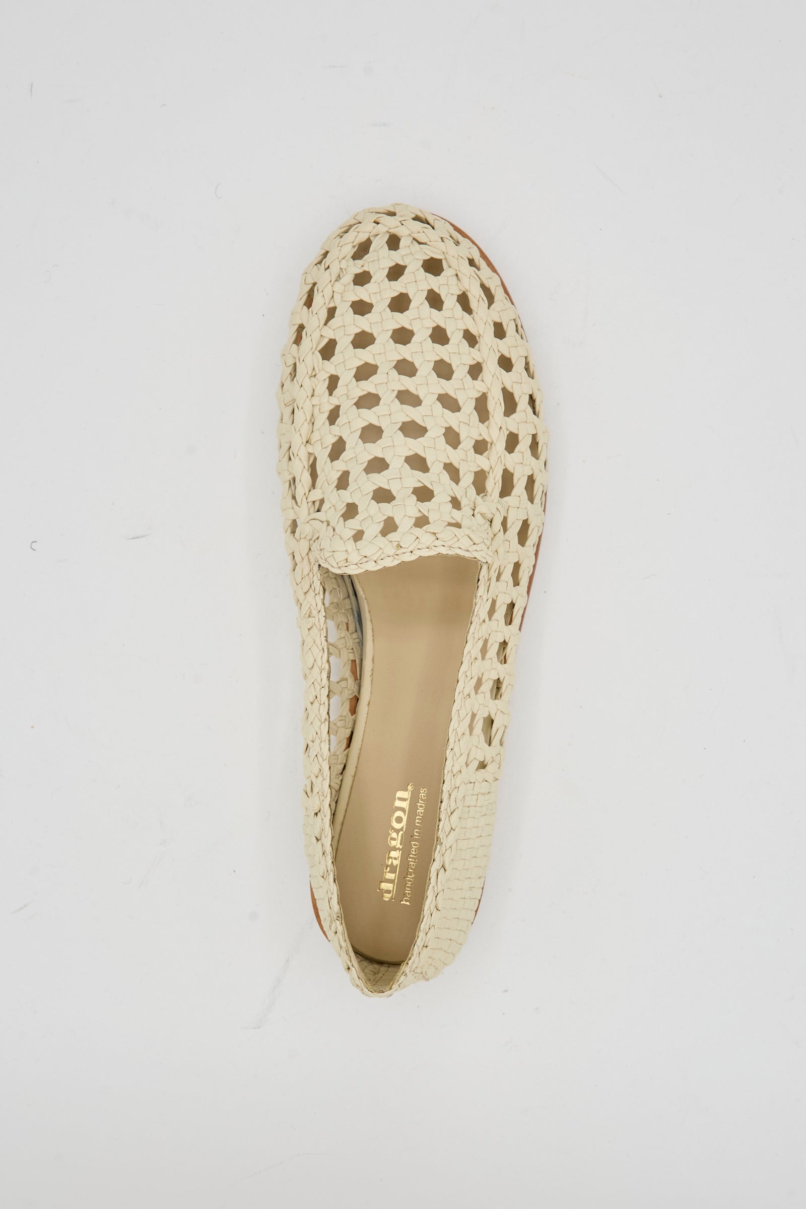 The Dragon Diffusion Dolly Moccasin in Off White, crafted from woven goat leather, features a closed toe and inner label. It's photographed from above on a white background.