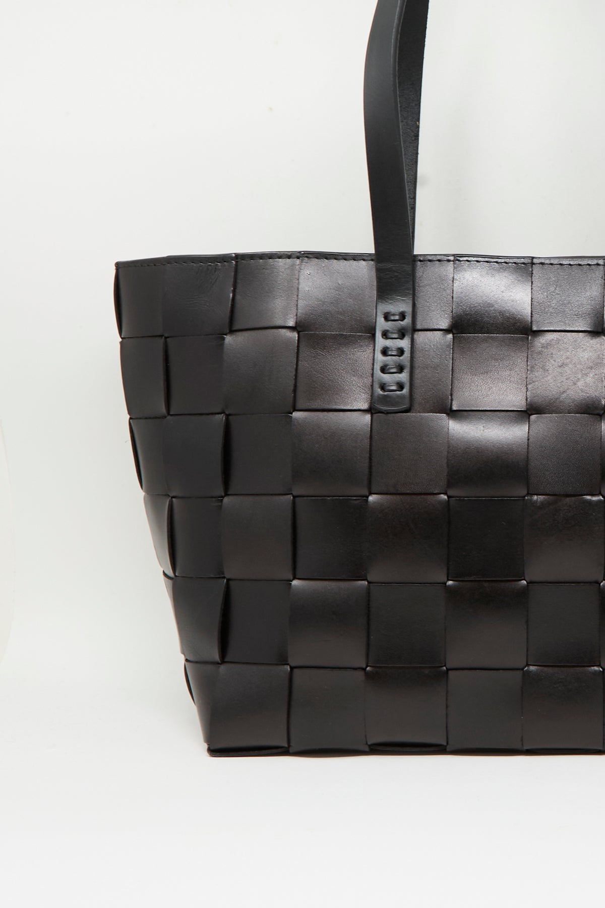 A close-up of the Dragon Diffusion Japan Tote in Black, a spacious basket-shaped bag crafted from black cross-woven leather with a flat handle, shown against a plain white background.