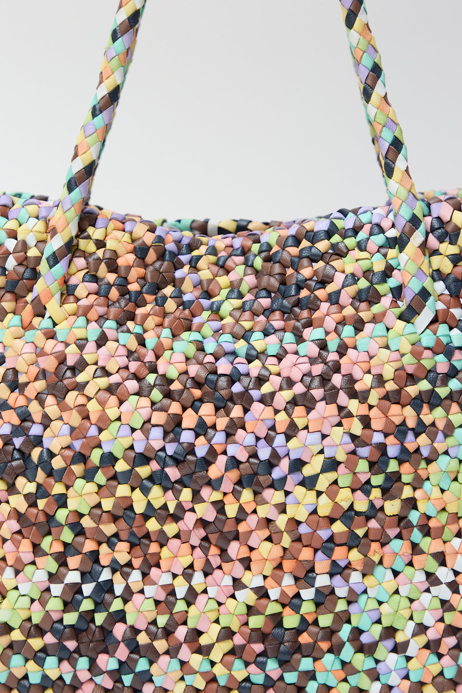 Close-up of a colorful Dragon Diffusion Octo Multi in Pastel woven leather tote with a detailed, multi-colored pattern.