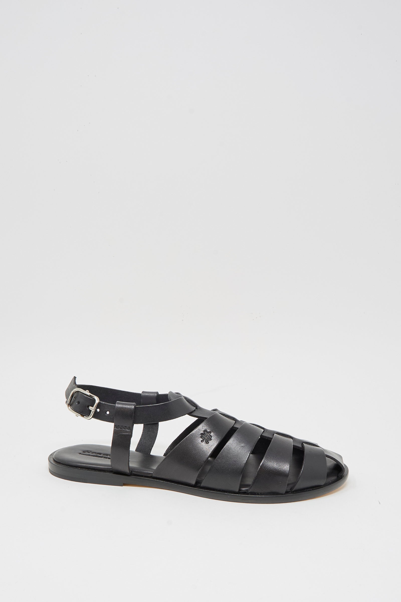 The Pescador Sandal in Black by Dragon Diffusion is a handcrafted fisherman sandal made from premium cow leather, with multiple straps, a closed toe, an ankle buckle strap, and a flat sole, shown on a white background.