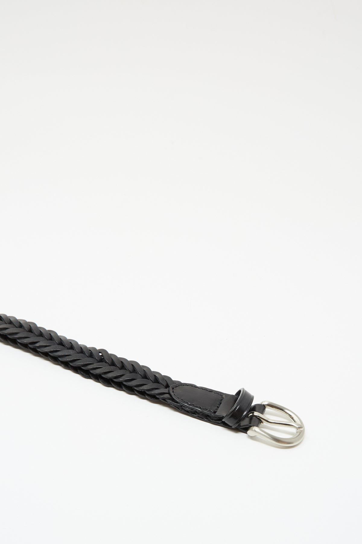 The Dragon Diffusion Single Link Belt in Black, featuring braided leather and a metal buckle, is laid diagonally on a white background.