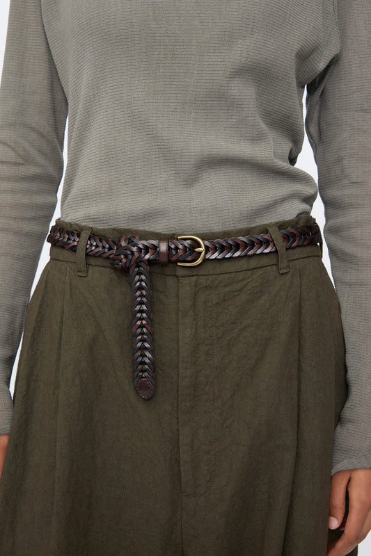 A person wears an olive green textured long-sleeve top, dark olive high-waisted pants, and the Dragon Diffusion Single Link Bi-Color Belt in Dark Brown and Black.