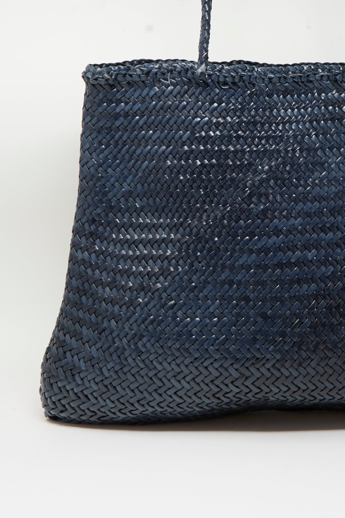 A close-up view of the Dragon Diffusion Sophie Large in Marine, a dark blue handwoven calf leather handbag, is shown against a plain white background.