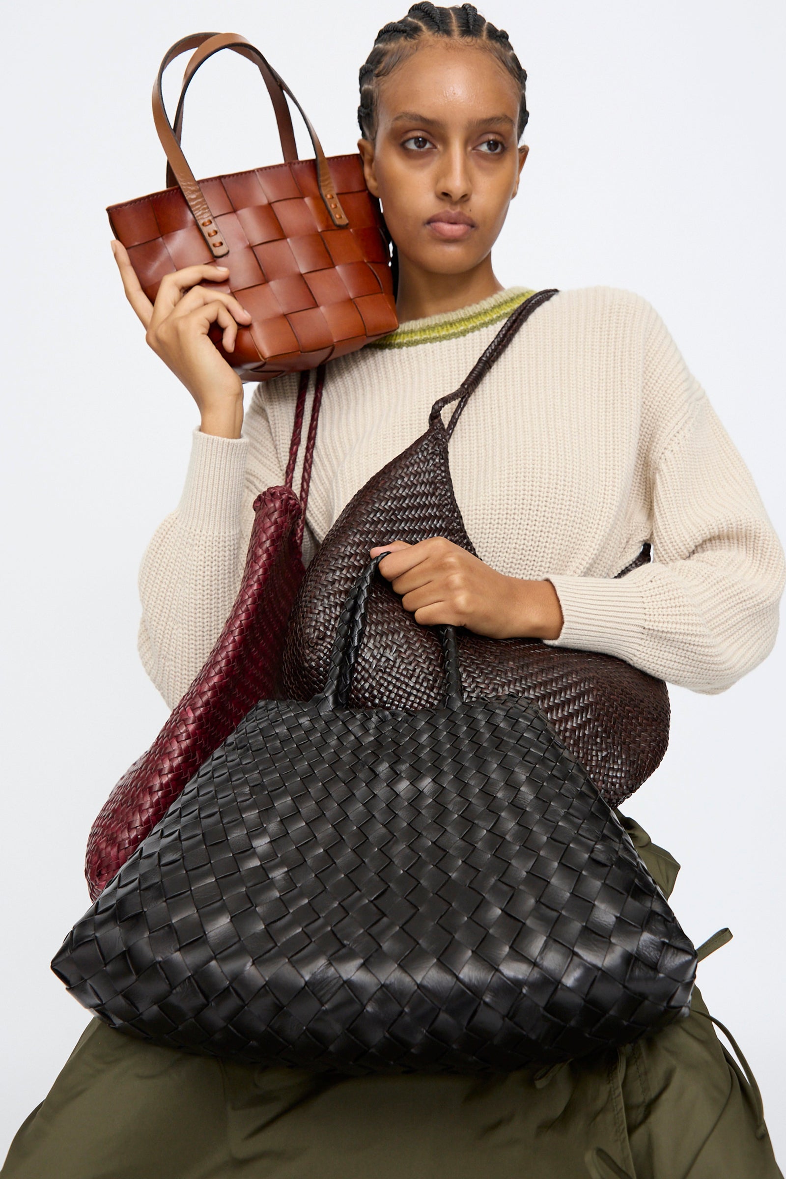 Woman holding Oroboro's collection of Dragon Diffusion bags, against a plain background.