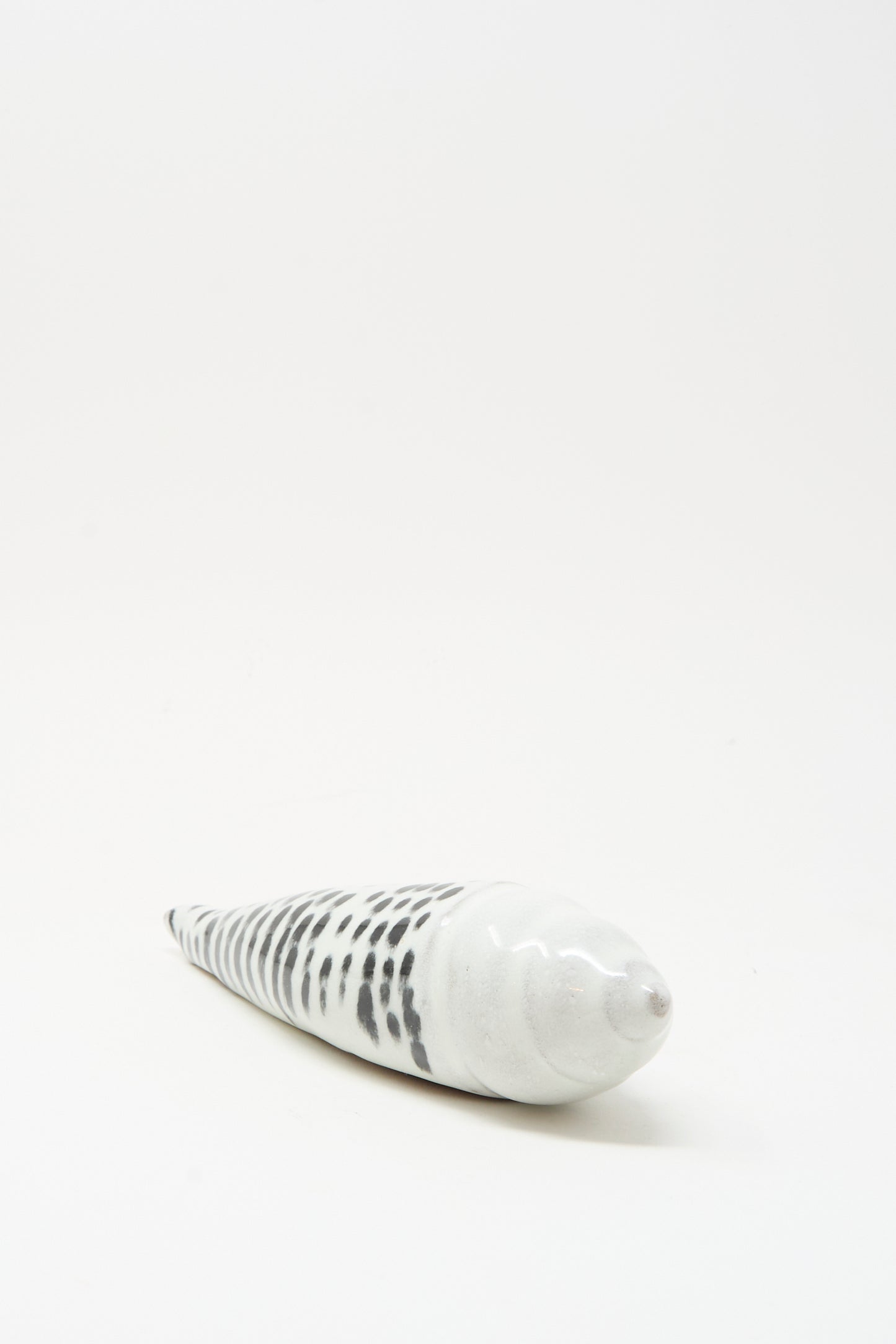 The Shell Rattle XCII by E.C.C.E is a handmade ceramic spiral shell with black and white markings, photographed on a plain white background.