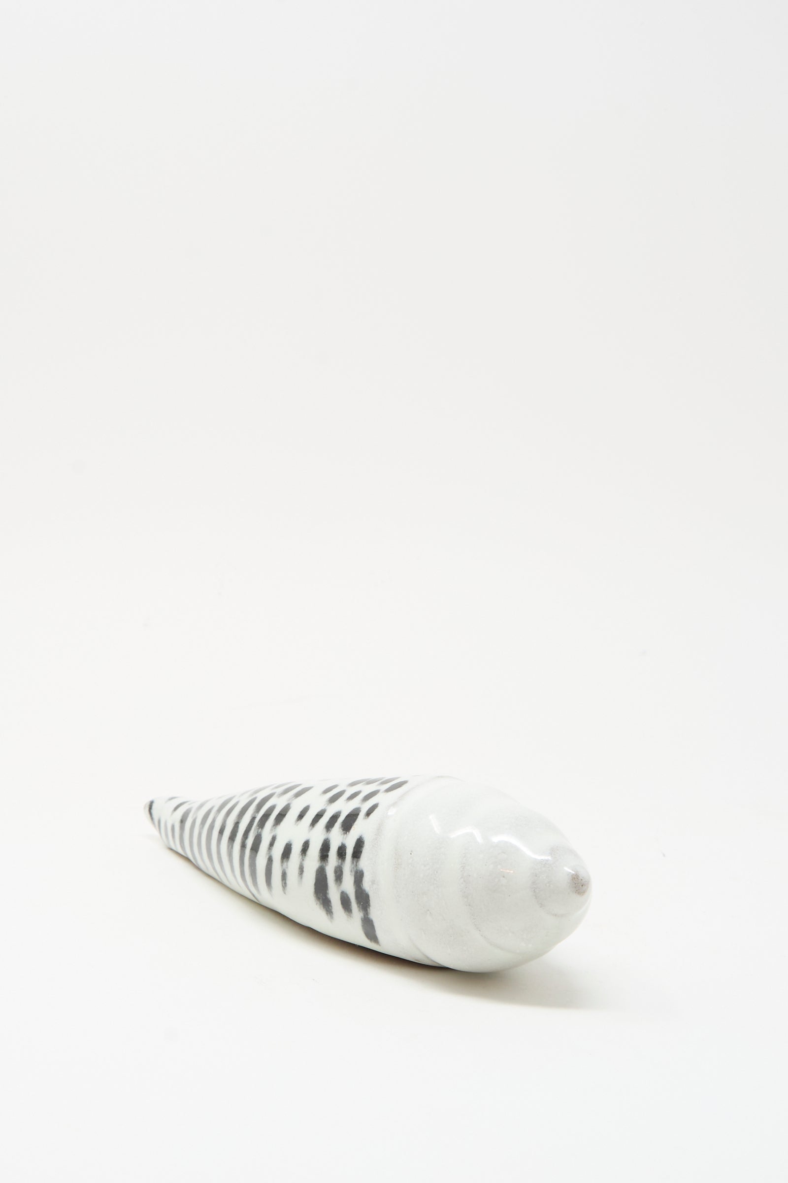 The Shell Rattle XCII by E.C.C.E is a handmade ceramic spiral shell with black and white markings, photographed on a plain white background.
