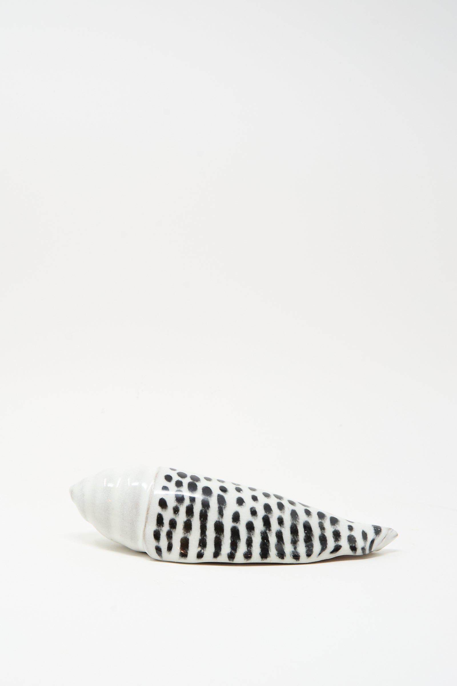 The Shell Rattle XCII by E.C.C.E is a handmade ceramic piece from NYC, featuring black spots and stripes, displayed on a plain white background.