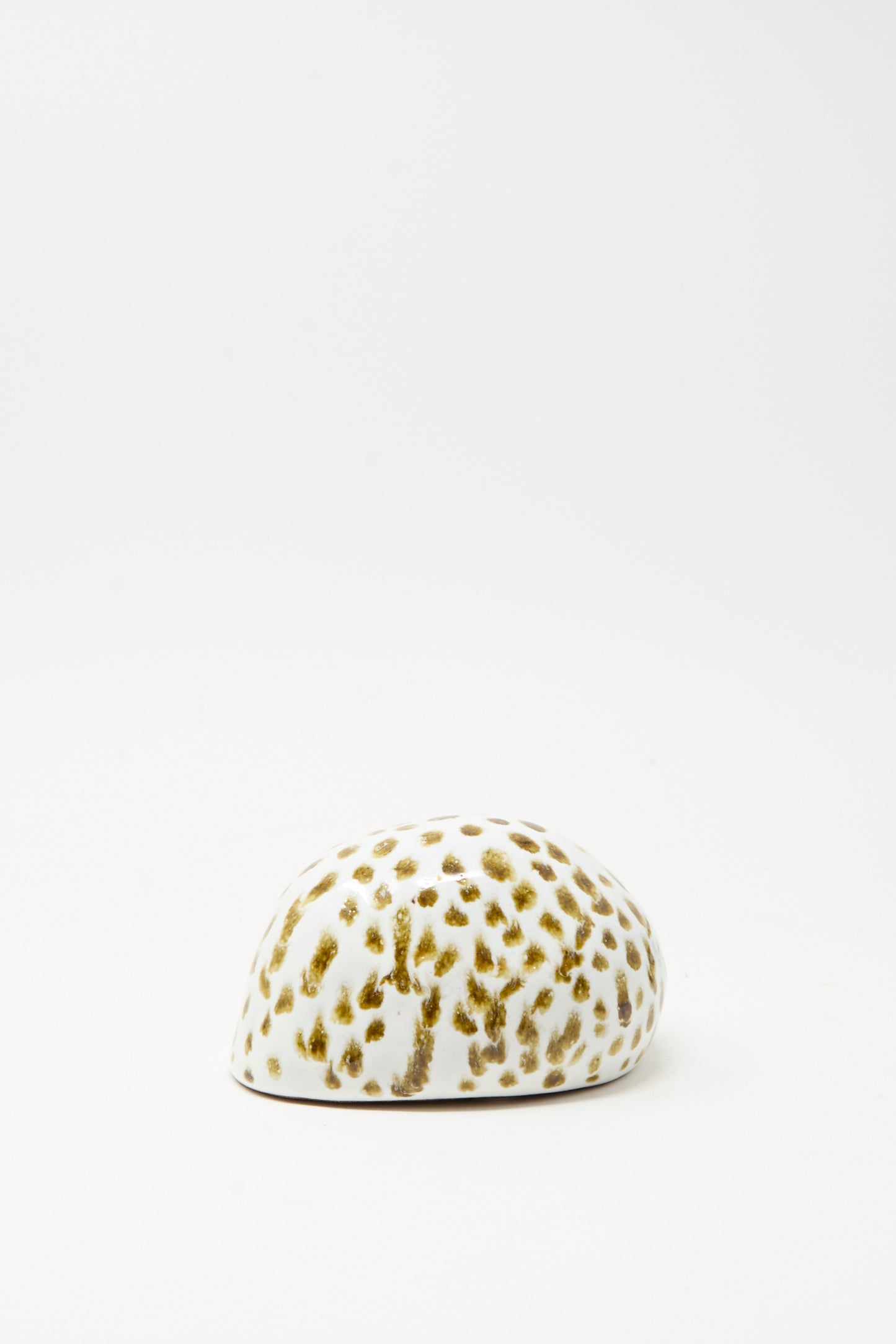 The Shell Rattle XCIV by E.C.C.E is a handmade white ceramic rattle with brown spots, crafted in NYC and displayed on a plain white background.