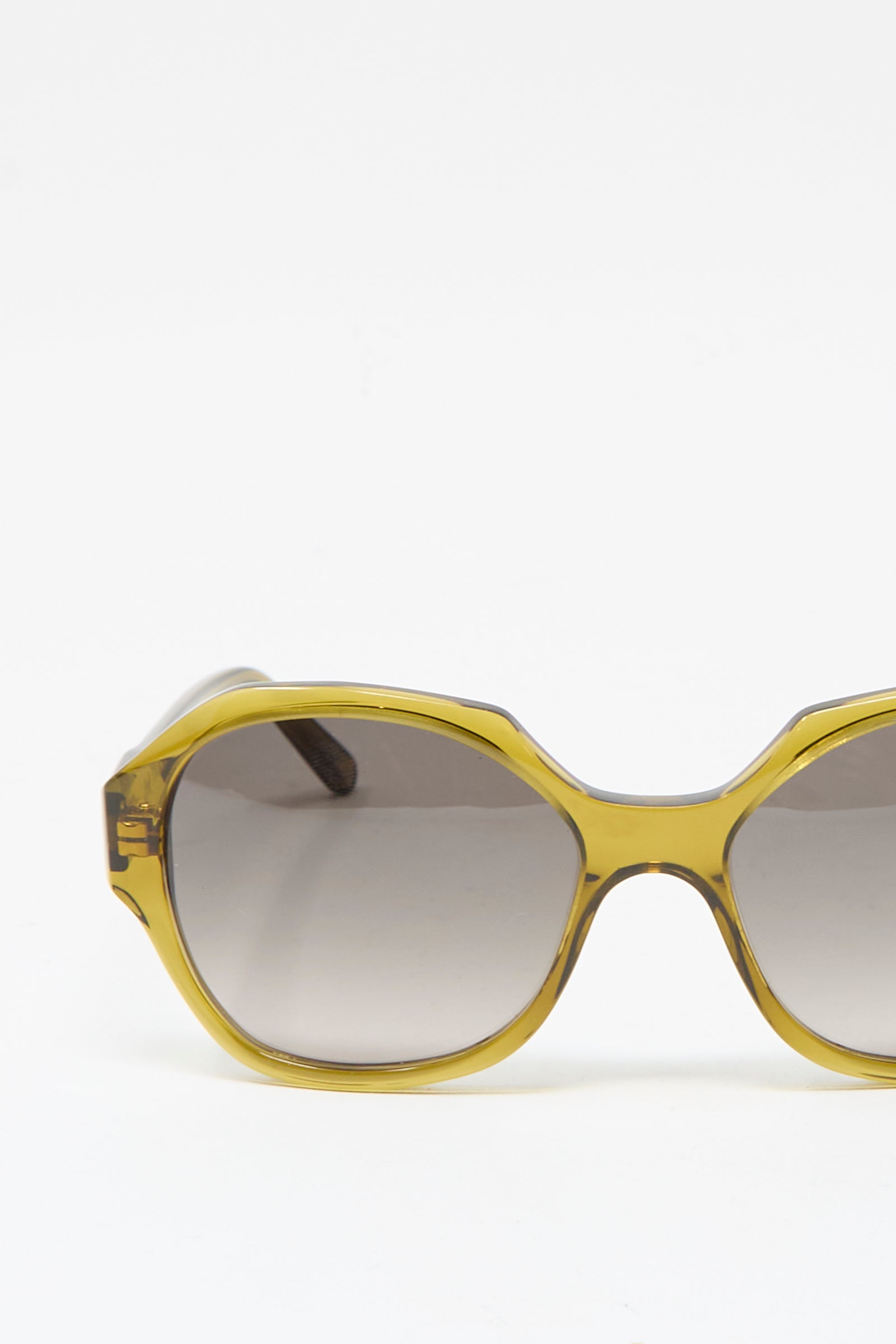 The Eva Masaki 001 Sunglasses in Zumi feature a yellow plastic oversized frame with dark tinted lenses, handmade in Italy. Shown against a white background with only the right half of the frame visible.