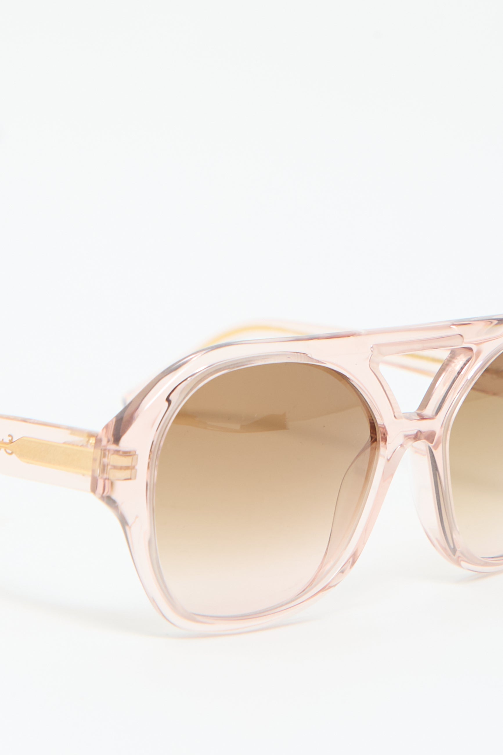 Close-up of Chiyo Aviators in Heart by Eva Masaki, featuring pink Italian acetate frames and brown gradient lenses on a white background, offering superior UV protection.