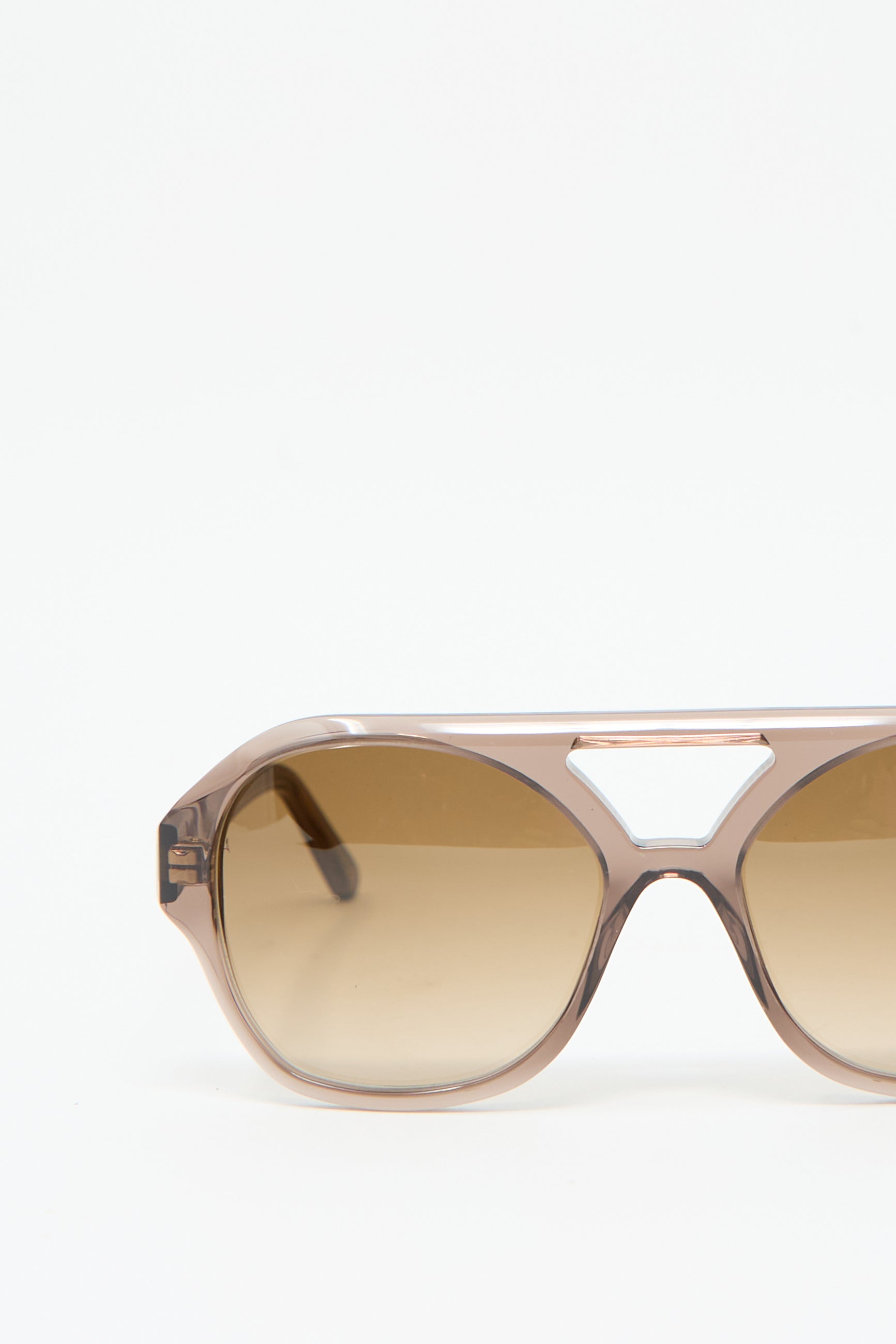 A close-up of the Chiyo Aviator Sunglasses in Shroom by Eva Masaki, featuring gradient brown lenses and a light tan aviator frame, crafted from luxurious Italian acetate, displayed against a plain white background.