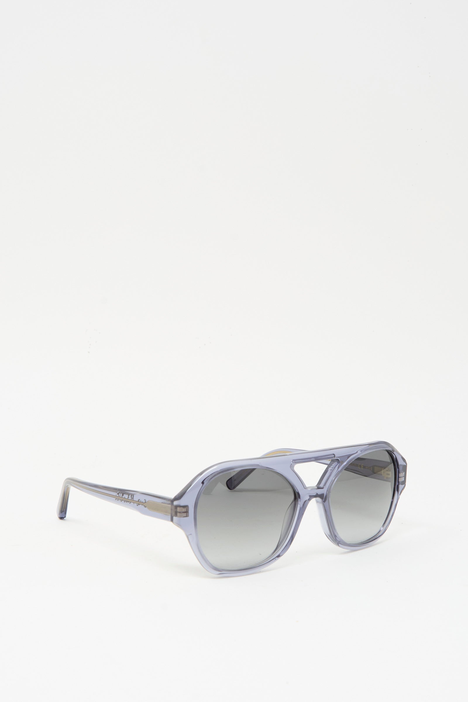The Chiyo Aviator Sunglasses in Waves by Eva Masaki feature translucent gray Italian acetate frames with dark tinted, UV-protective lenses, shown against a plain white background.