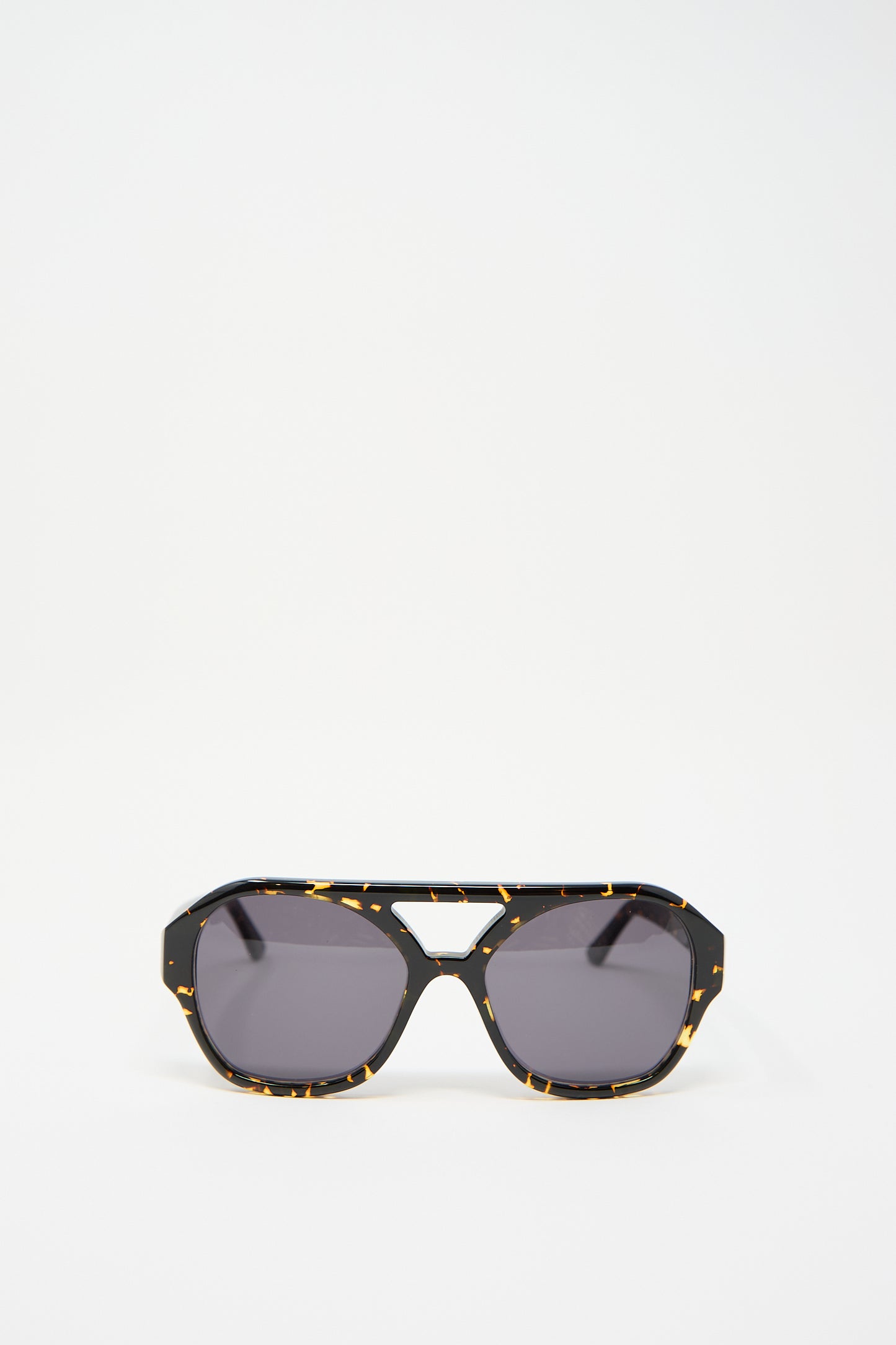 The Chiyo Aviator Sunglasses in Gotham by Eva Masaki feature frames crafted from elegant Italian acetate in a striking black and yellow tortoiseshell pattern, set against a plain white background.