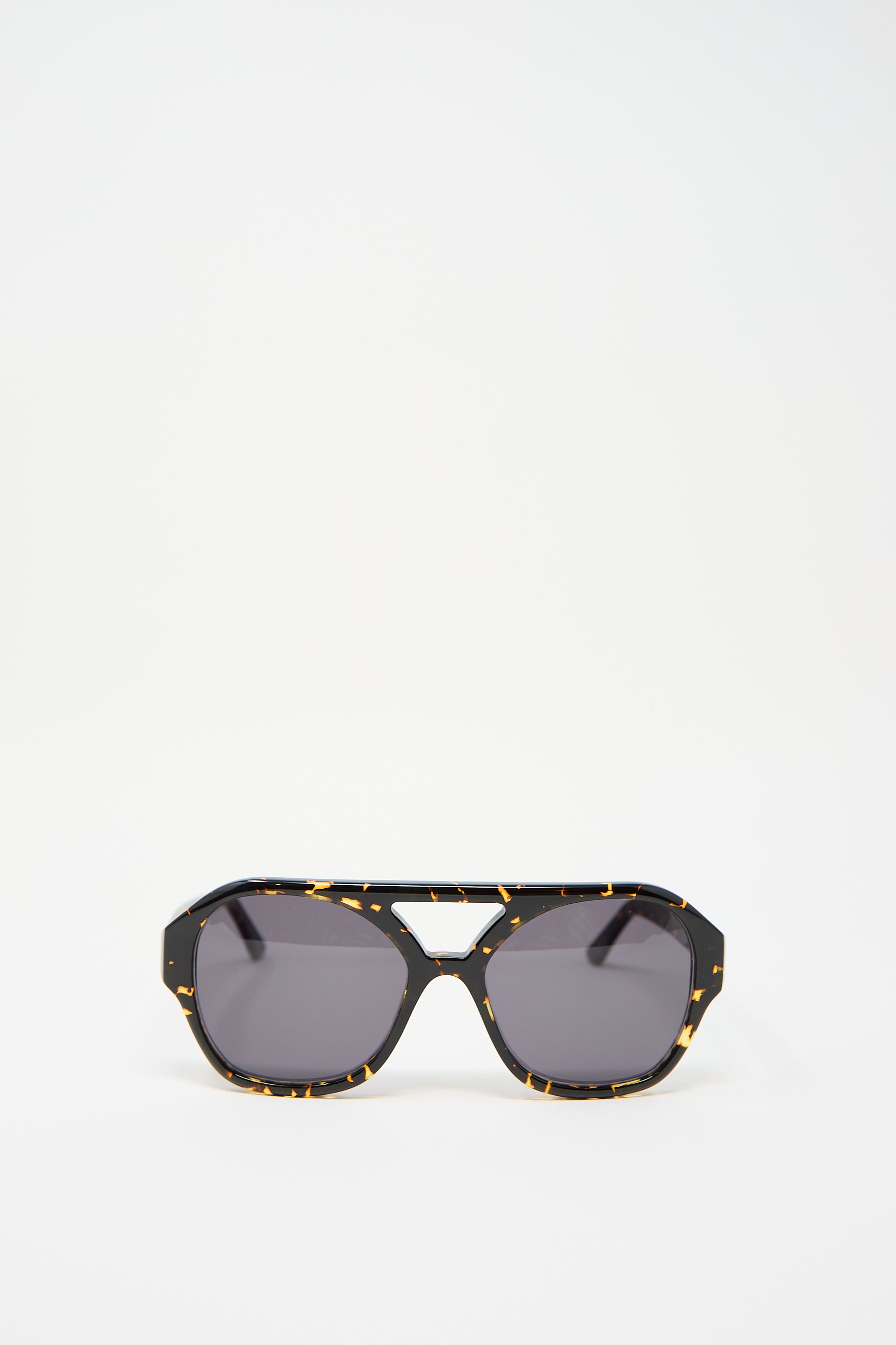 The Chiyo Aviator Sunglasses in Gotham by Eva Masaki feature frames crafted from elegant Italian acetate in a striking black and yellow tortoiseshell pattern, set against a plain white background.