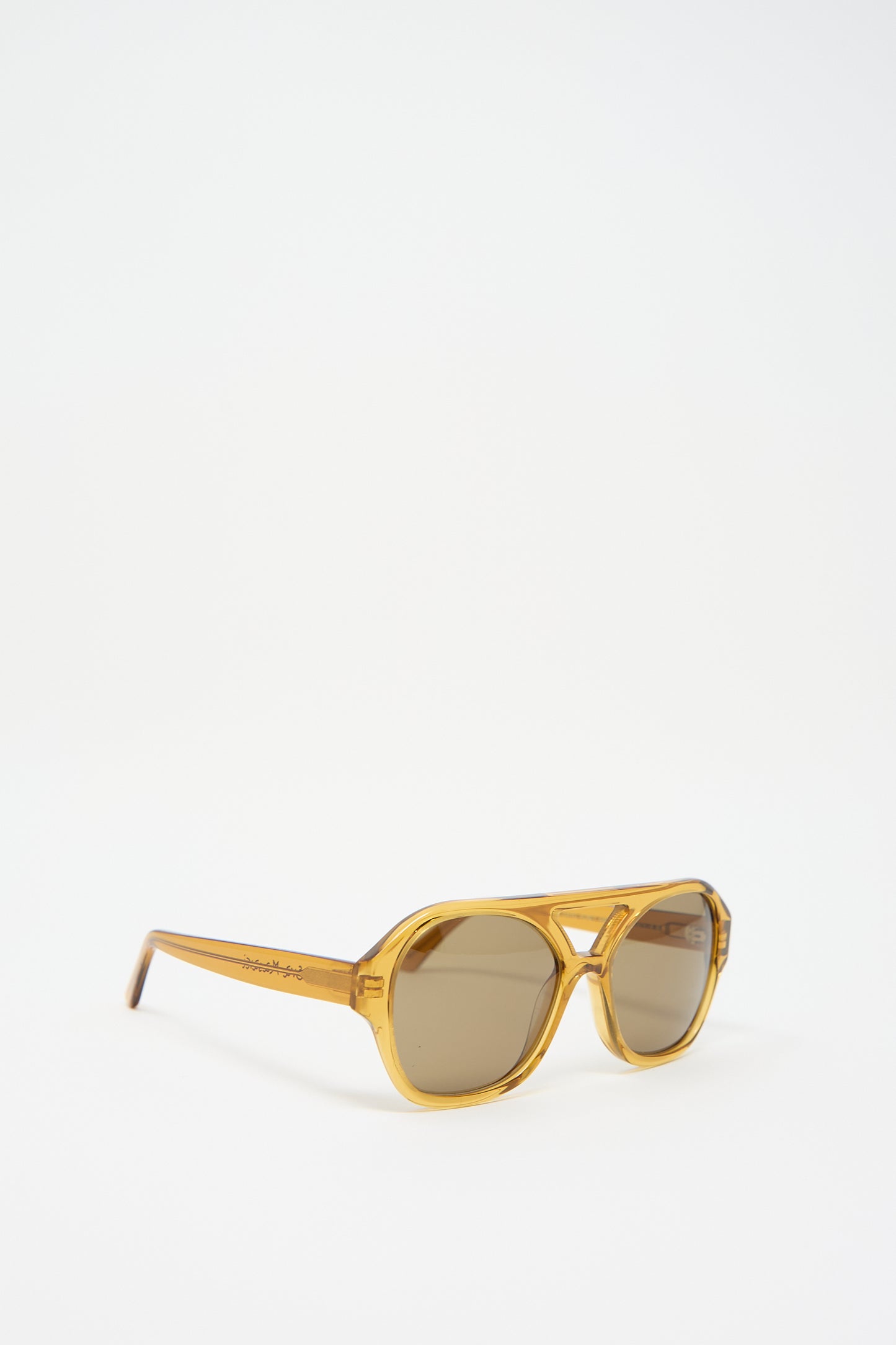 A pair of Chiyo Aviator Sunglasses in Honey by Eva Masaki with dark lenses, crafted from Italian acetate, is displayed against a white background. These stylish shades not only offer a chic look but also provide superior UV protection for your eyes.