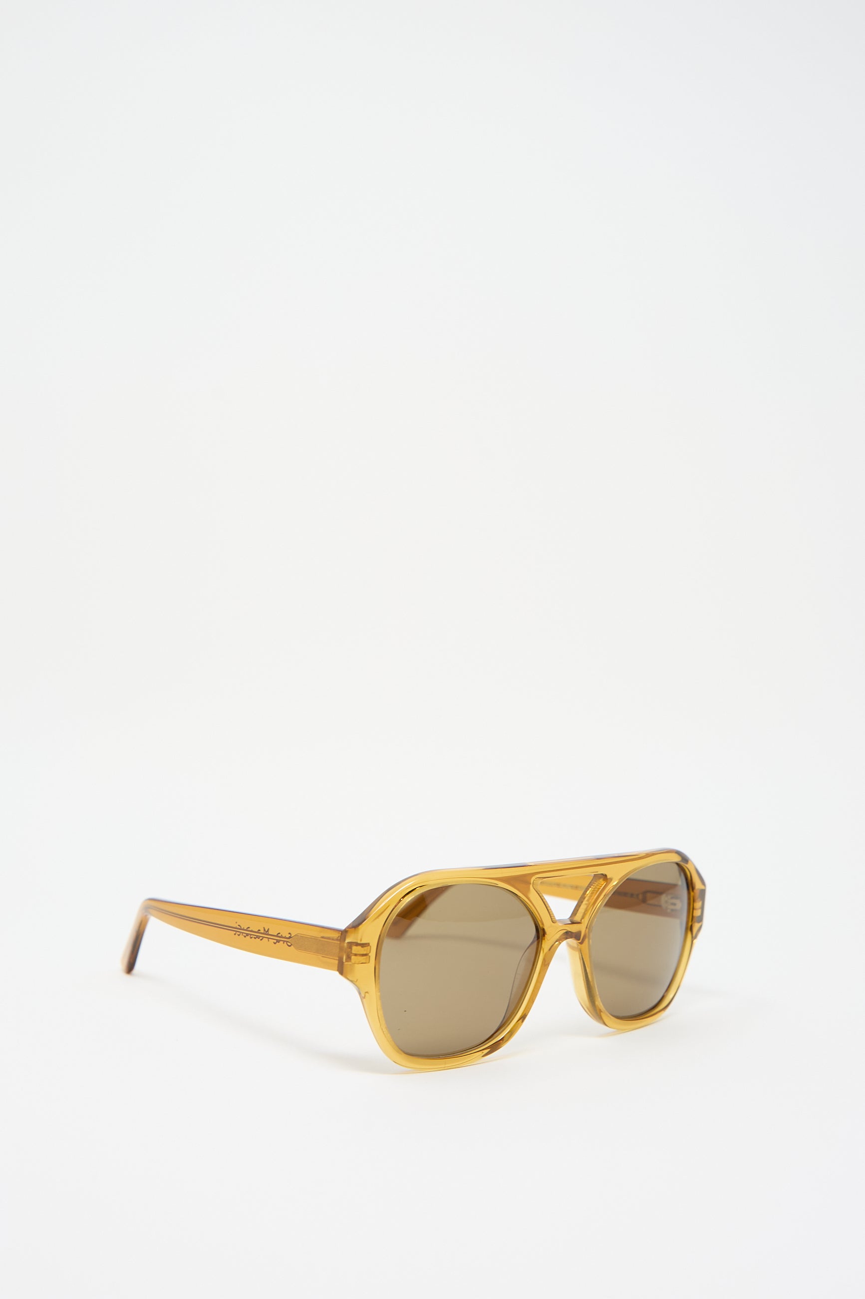 A pair of Chiyo Aviator Sunglasses in Honey by Eva Masaki with dark lenses, crafted from Italian acetate, is displayed against a white background. These stylish shades not only offer a chic look but also provide superior UV protection for your eyes.