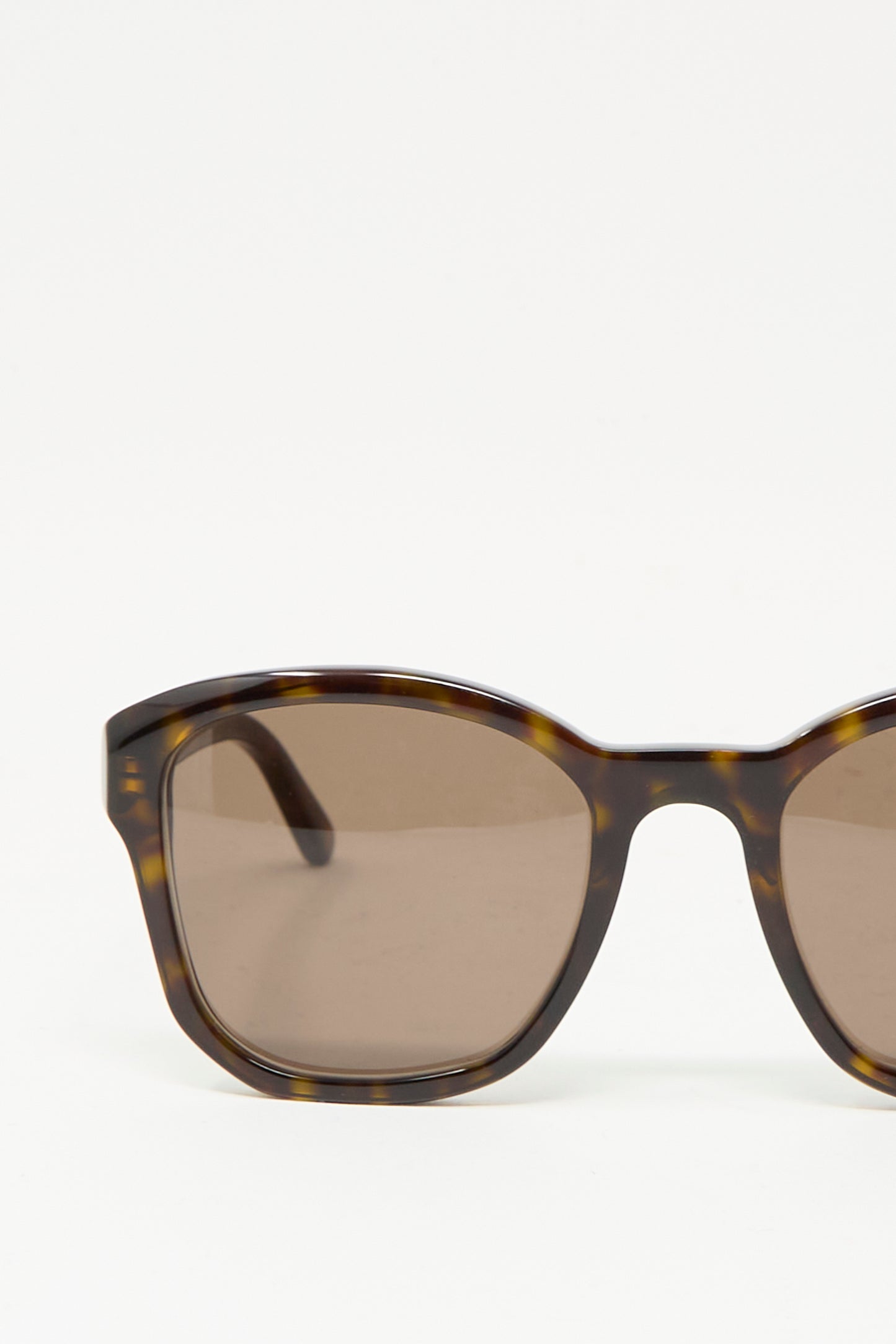 Close-up of Eva Masaki BQE Sunglasses in Finch, featuring a Havana tortoise shell frame, rectangular lenses, and 100% UV protection, set against a plain white background.