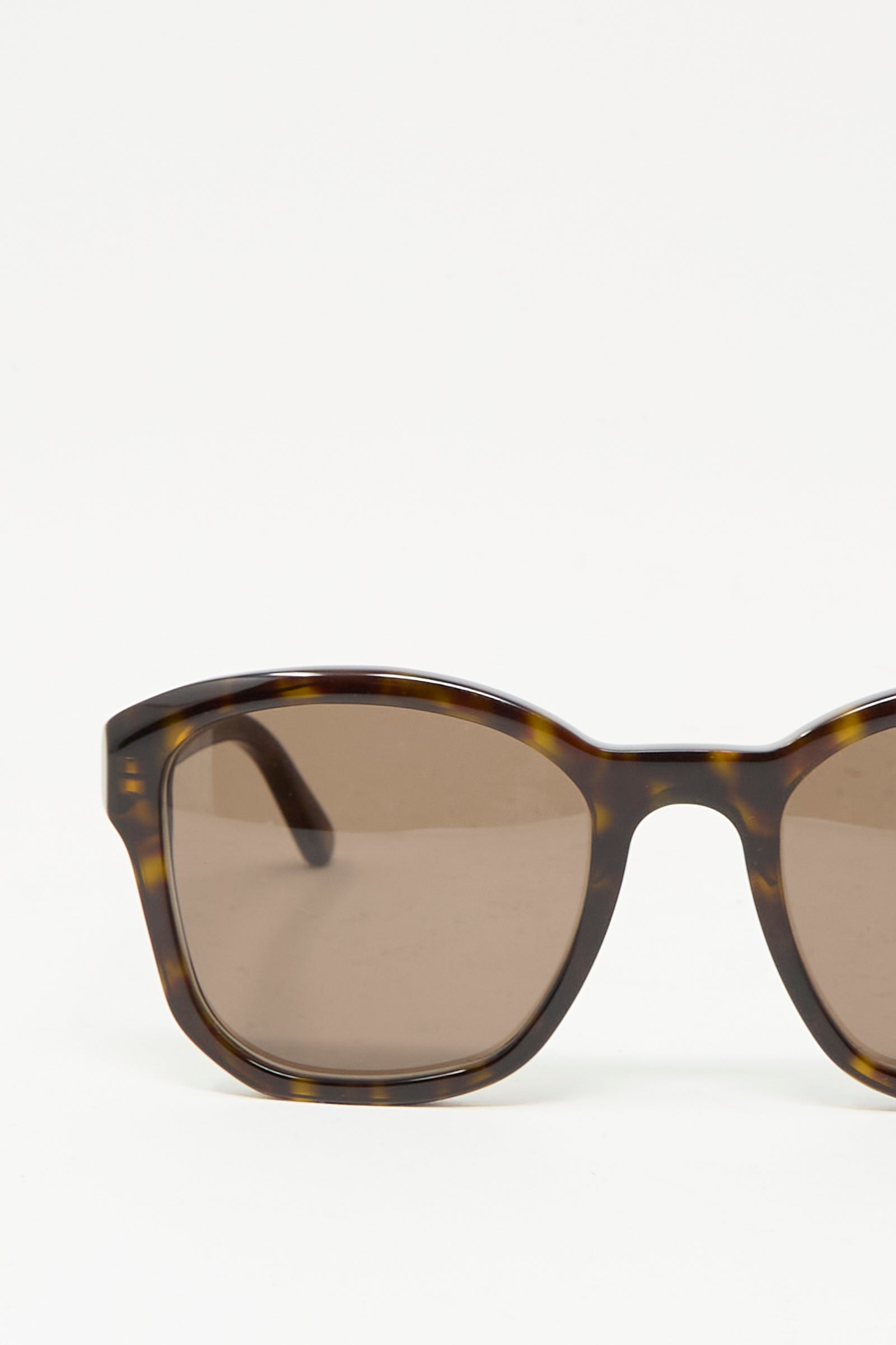 Close-up of Eva Masaki BQE Sunglasses in Finch, featuring a Havana tortoise shell frame, rectangular lenses, and 100% UV protection, set against a plain white background.