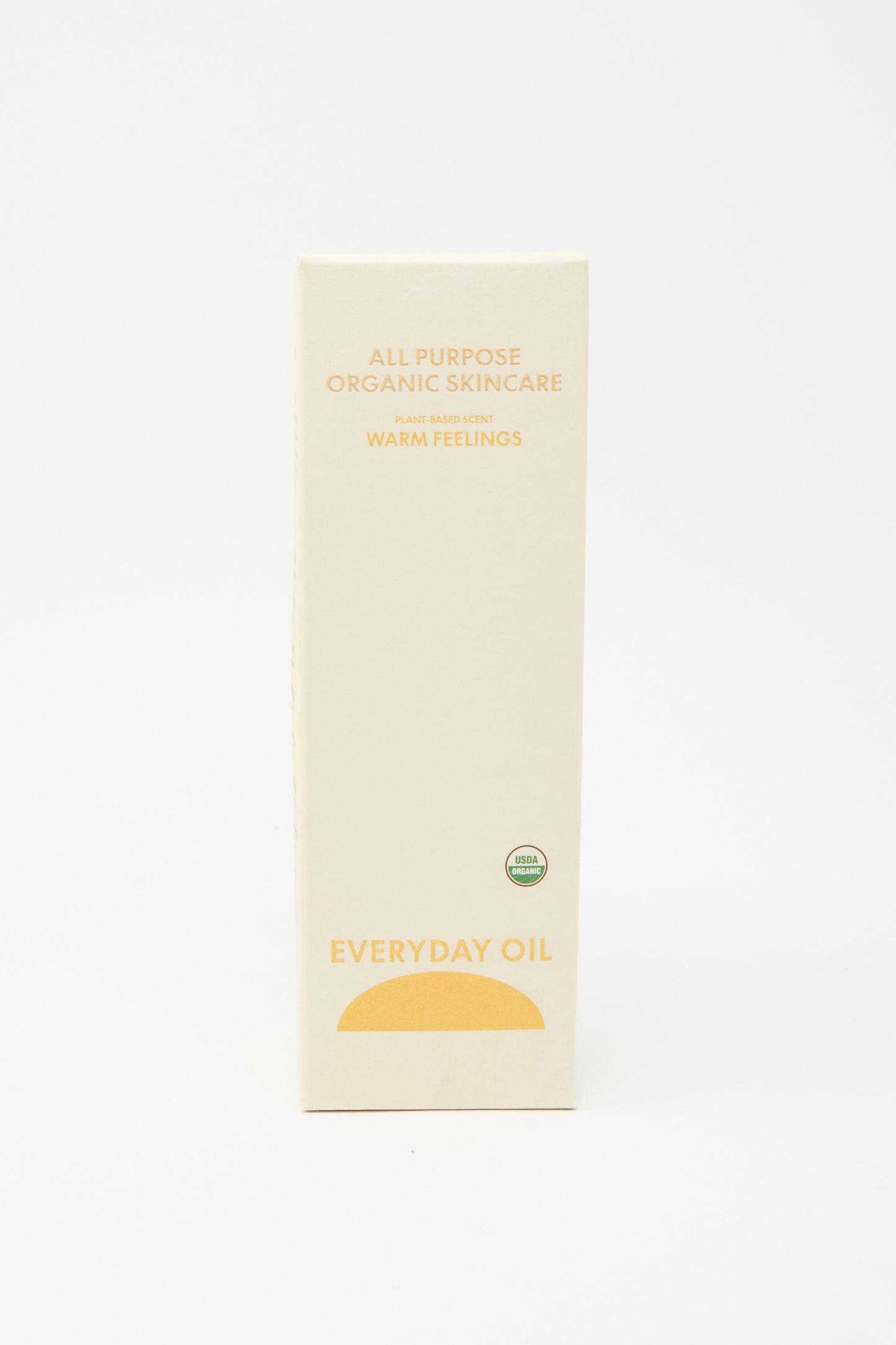 A beige rectangular box labeled "Everyday Oil Warm Feelings - 8 Ounces," an all-natural, plant-based moisturizer, stands upright against a plain white background.