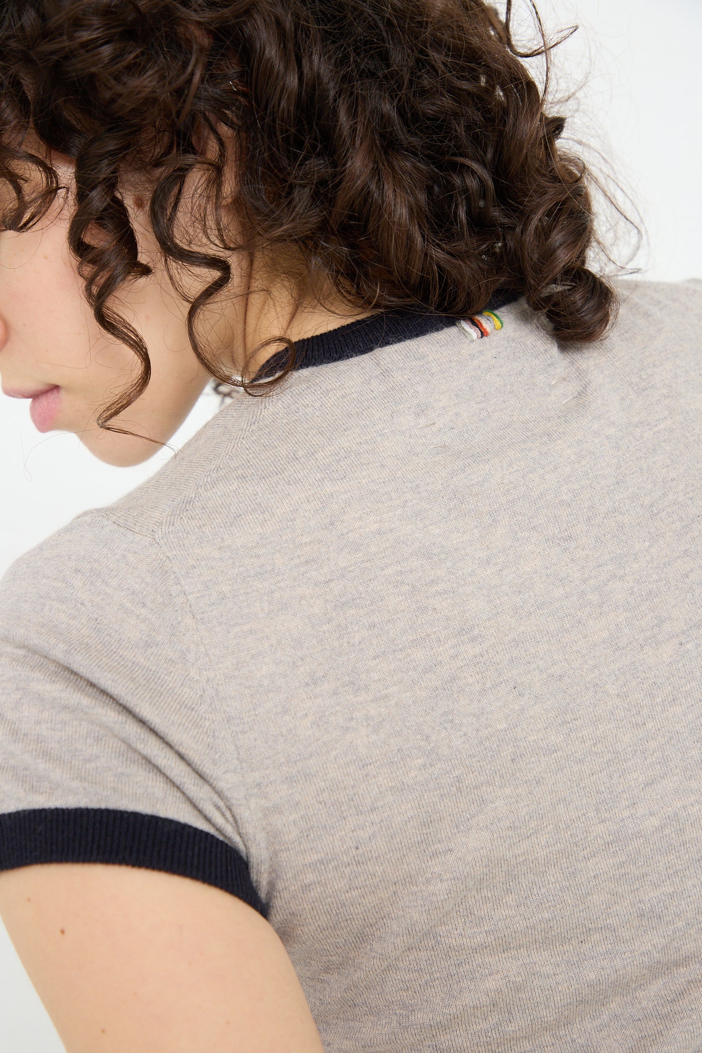 A woman wearing an Extreme Cashmere Cotton Cashmere No. 339 Chloe Tee in Gray/Navy is seen from the back.