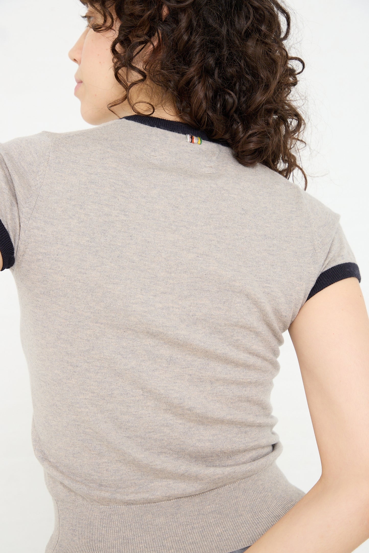 The woman is wearing a Cotton Cashmere No. 339 Chloe Tee in Gray/Navy by Extreme Cashmere.