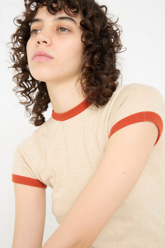 A woman wearing a Extreme Cashmere Cotton Cashmere No. 339 Chloe Tee in Beige/Orange.