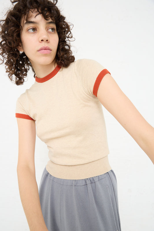 A woman in an Extreme Cashmere Cotton Cashmere No. 339 Chloe Tee in Beige/Orange and grey pants.