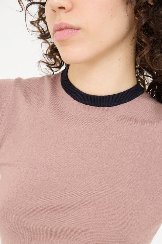 A woman in a Extreme Cashmere Cotton Cashmere No. 339 Chloe Tee in Mauve/Navy with curly hair.