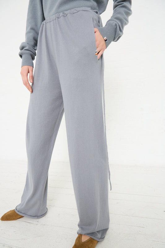 The model is wearing a grey sweatshirt and Extreme Cashmere's No. 278 Judo Pant in Sage.