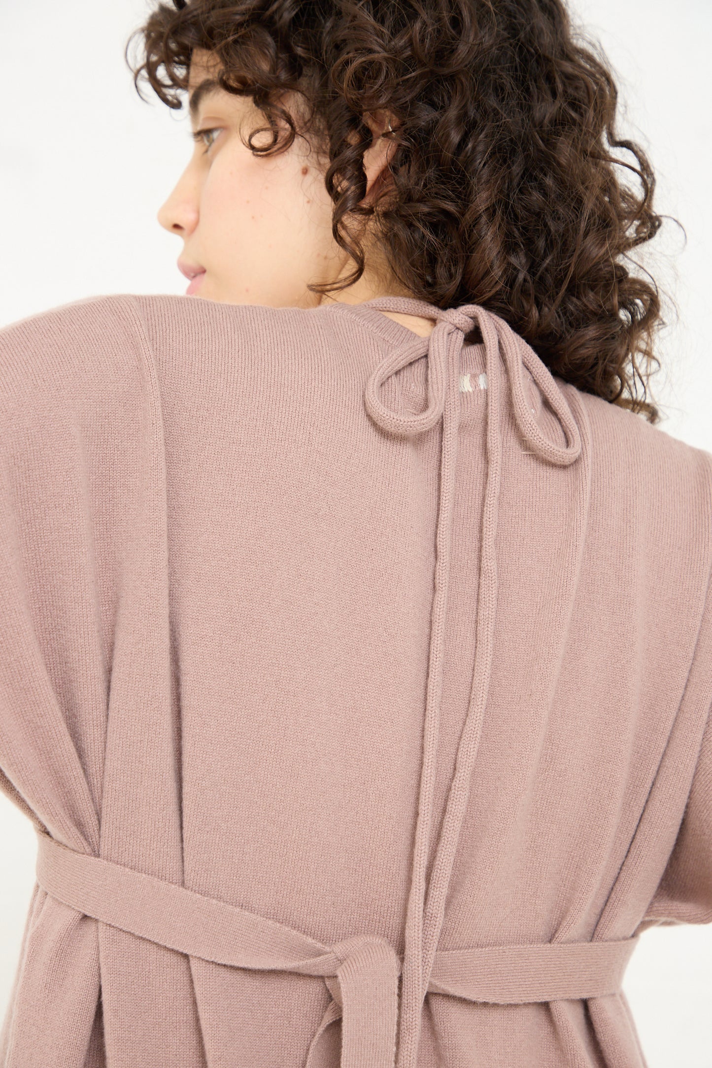 The woman is wearing an Extreme Cashmere No. 327 Bralette in Clay, showing off the back view.
