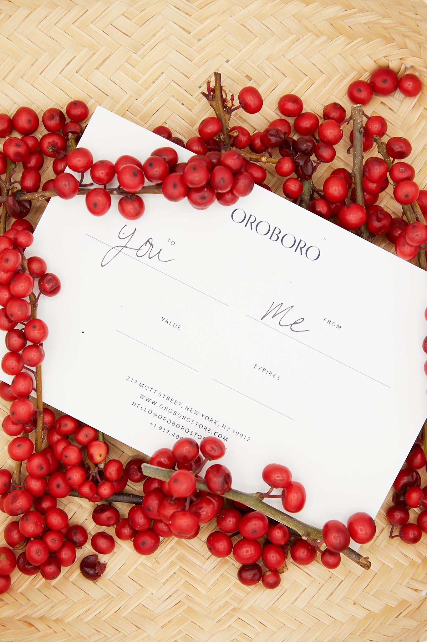 An Oroboro gift card with red berries around it.