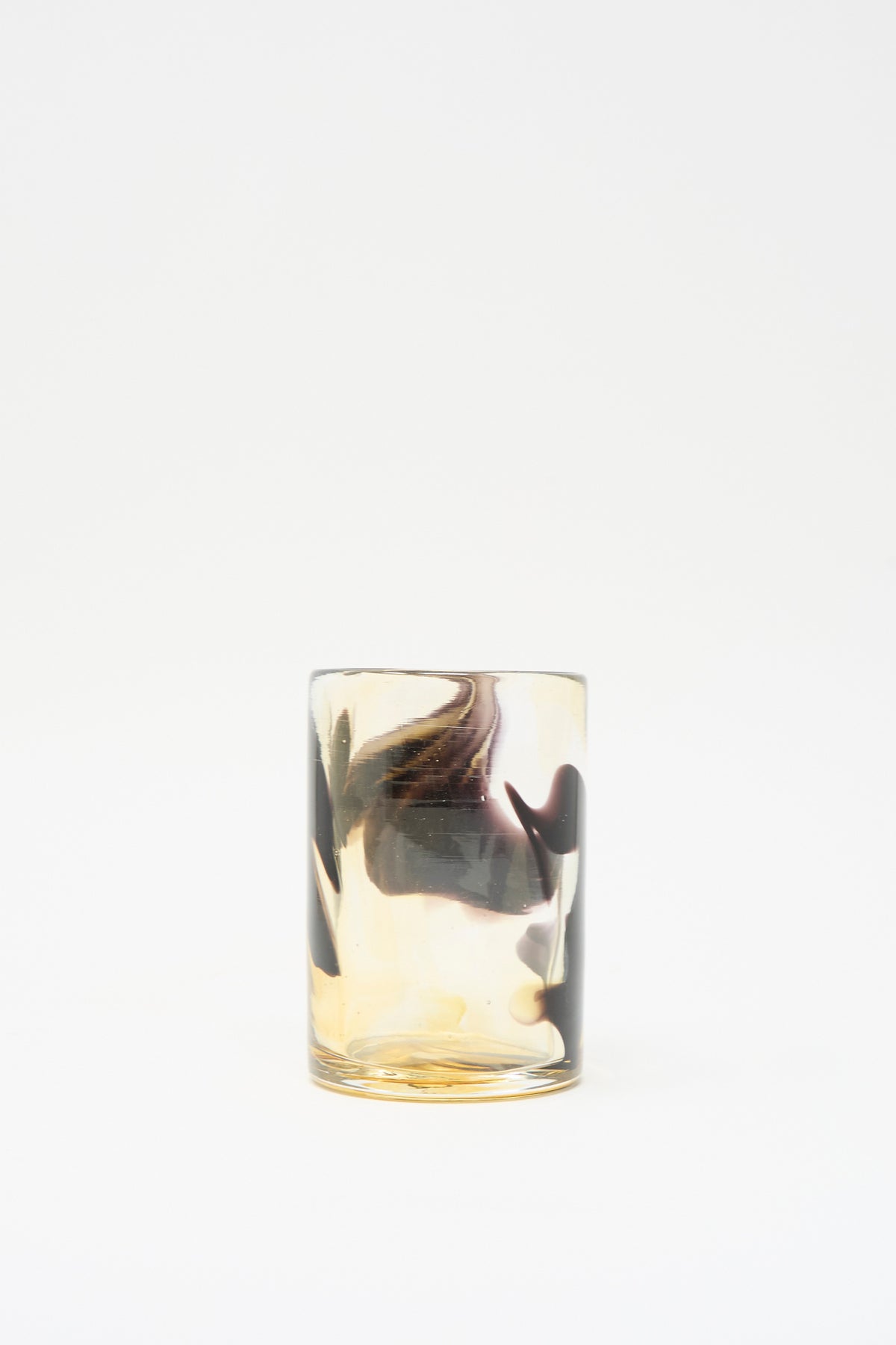 Gone Hand Dyed Fumé Glass cylindrical handmade tumbler featuring swirling amber and dark grey patterns.