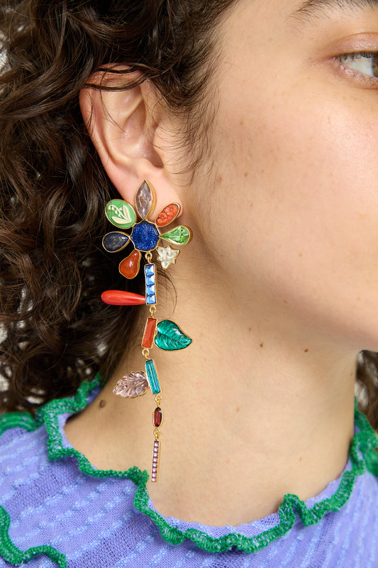 A woman wearing a colorful Grainne Morton Anniversary Flower Earring drop earring.