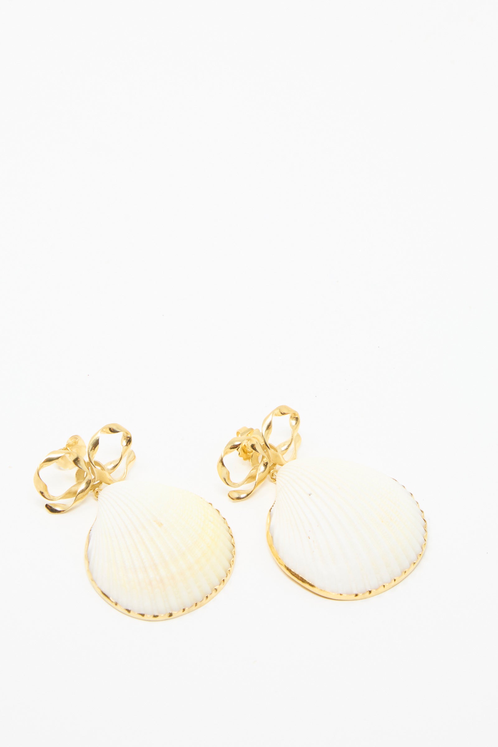 Grainne Morton's Bow and Shell Earrings feature gold and white seashells with ornate bow-shaped studs, made from 18k gold-plated silver on a plain white background.