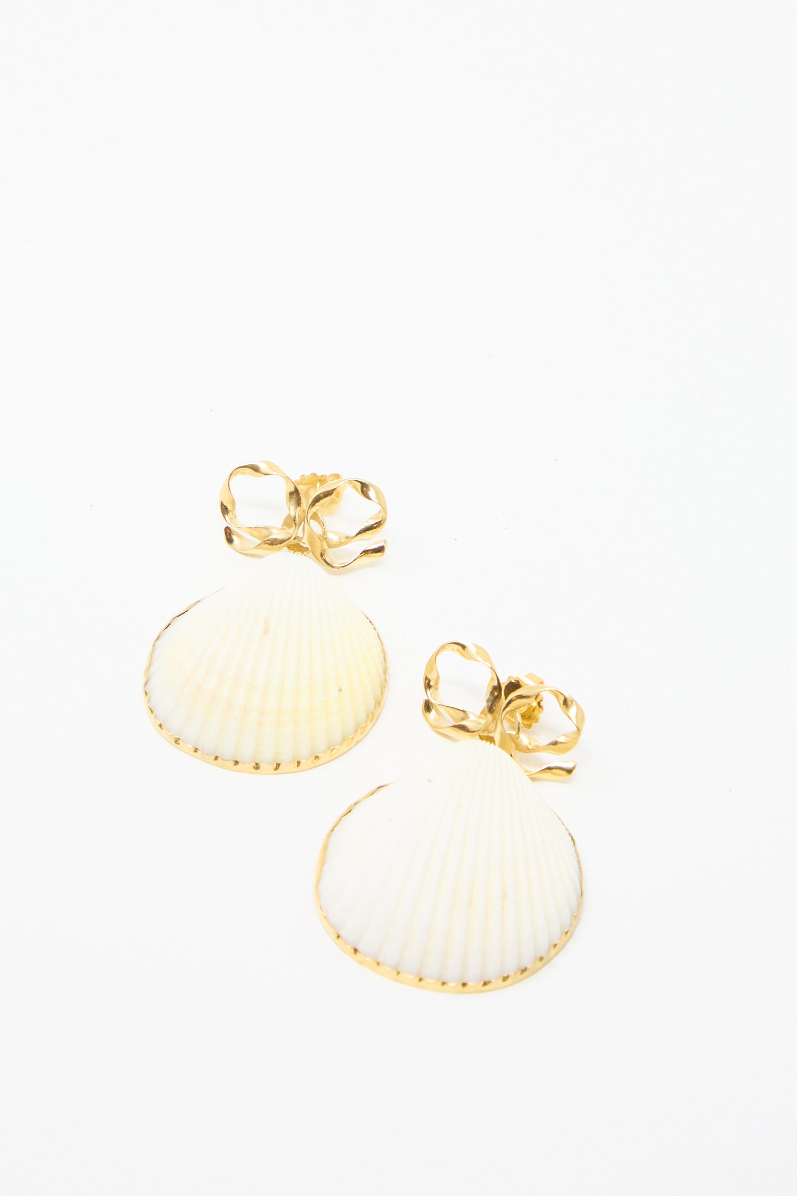 Grainne Morton's Bow and Shell Earrings: 18k gold-plated silver with shell-shaped pendants and decorative bows, set against a white background.