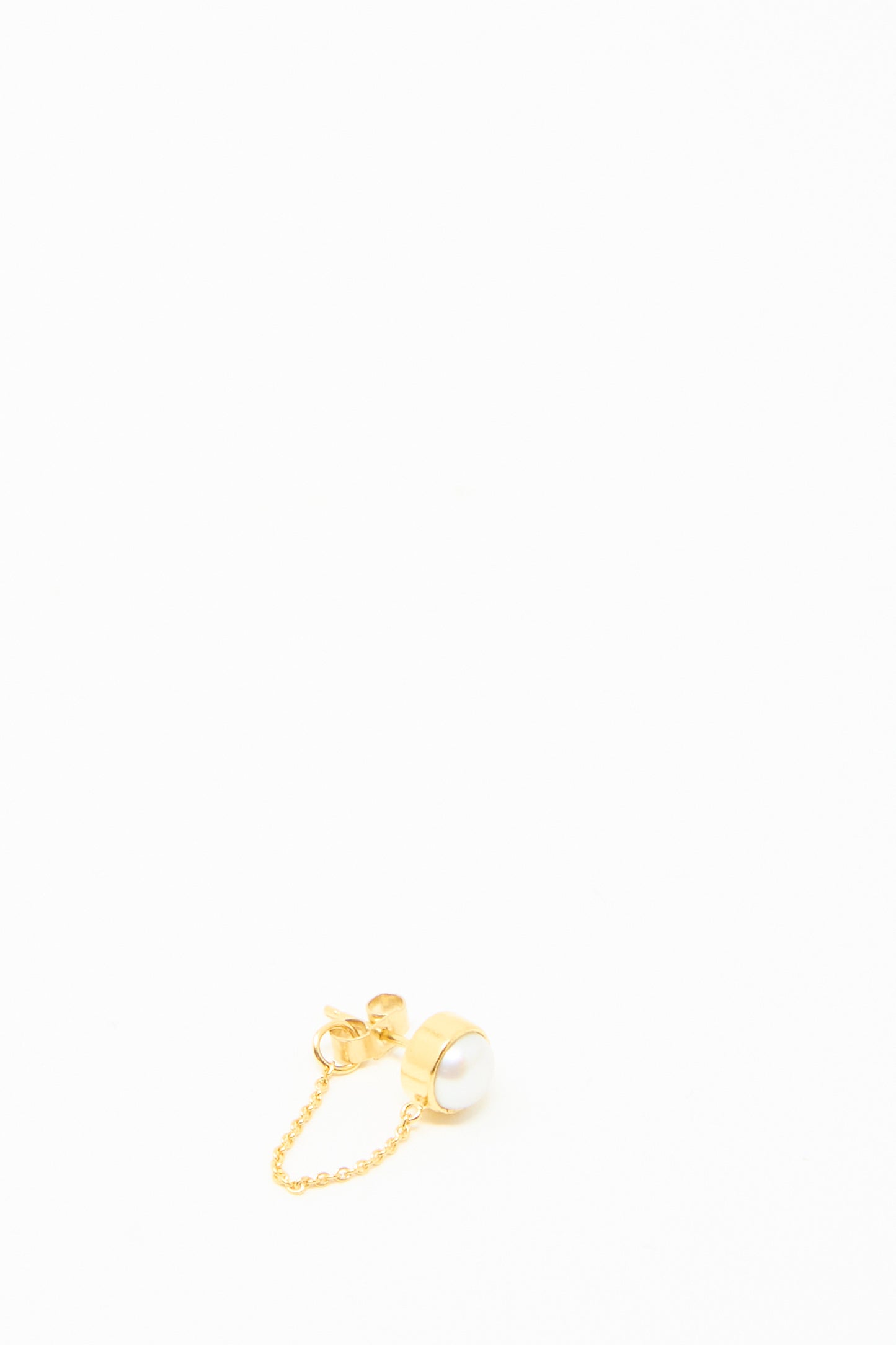 The Grainne Morton Chain Stud Earring showcases a radiant white pearl on 18k gold-plated silver with a short, elegant chain, all set against a pristine white background.