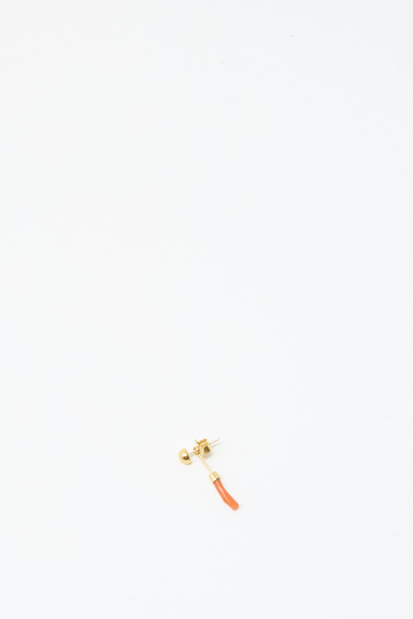 The Grainne Morton Detachable Drop Earring in Coral is a single 18K gold plated earring, handmade in Edinburgh, featuring a small curved orange pendant, shown against a plain white background.