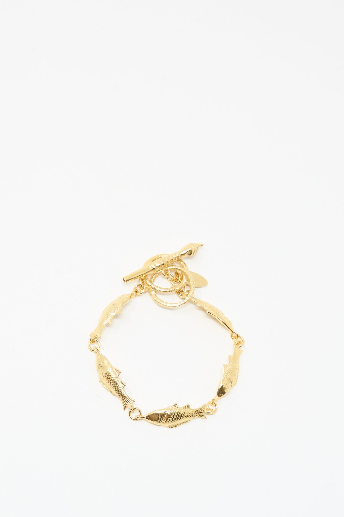 The Grainne Morton Fish Bracelet features gold plated silver fish-shaped links and a toggle clasp, handmade in Edinburgh. Displayed on a plain white background.