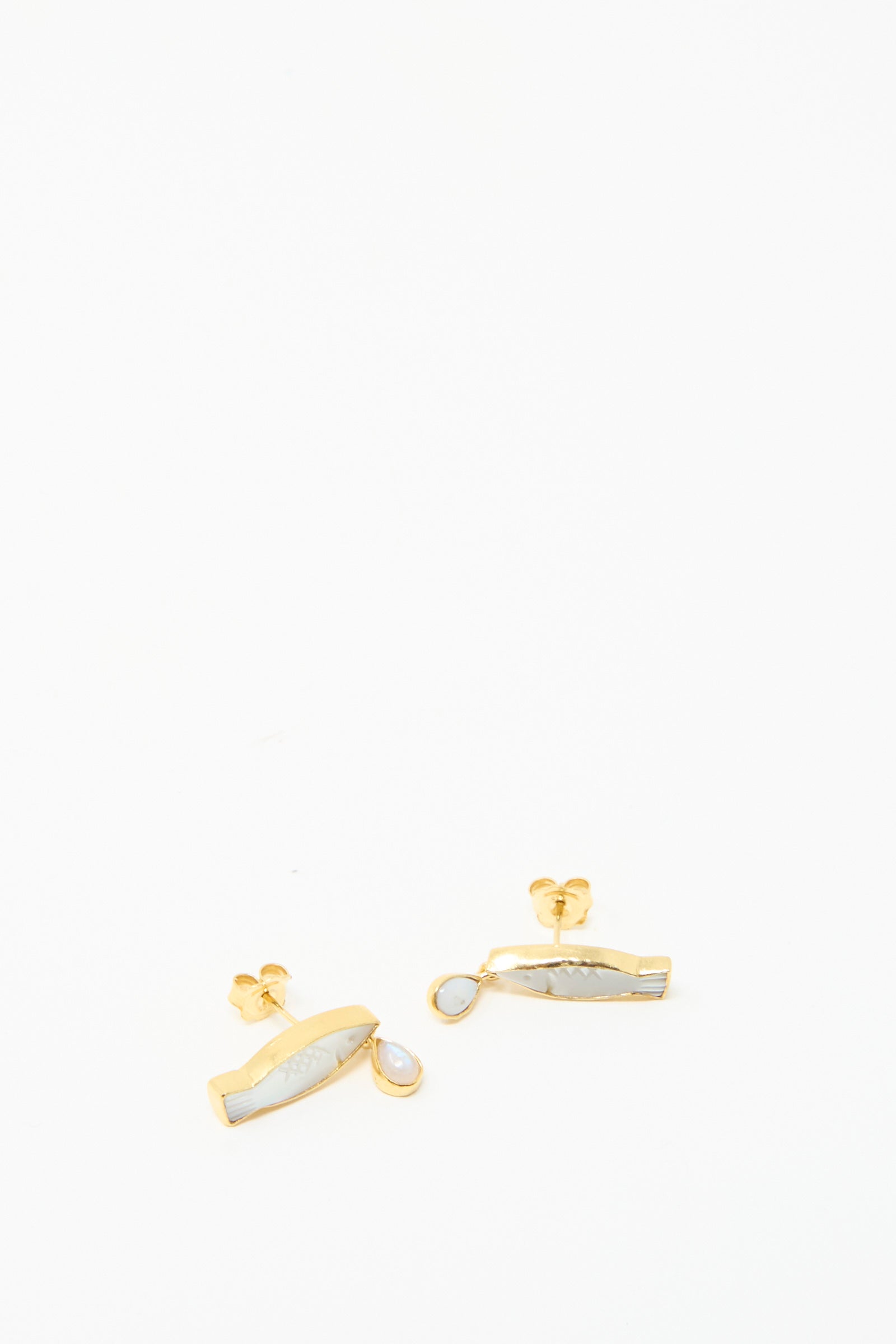 Grainne Morton's Fish Drop Earrings features white gemstones enclosed in gold plated silver, set against a simple white background.