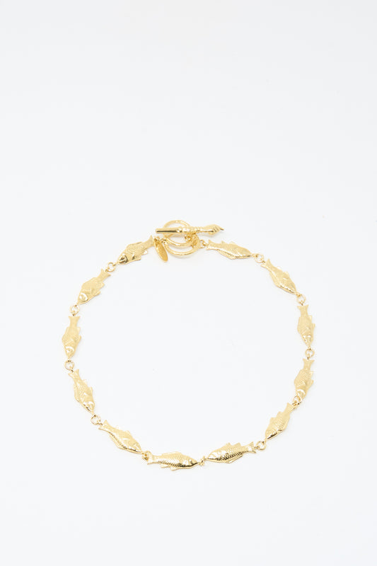 A Fish Necklace by Grainne Morton, featuring gold-plated silver with small leaf-shaped links and a circular toggle clasp, handmade in Edinburgh and shown on a plain white background.