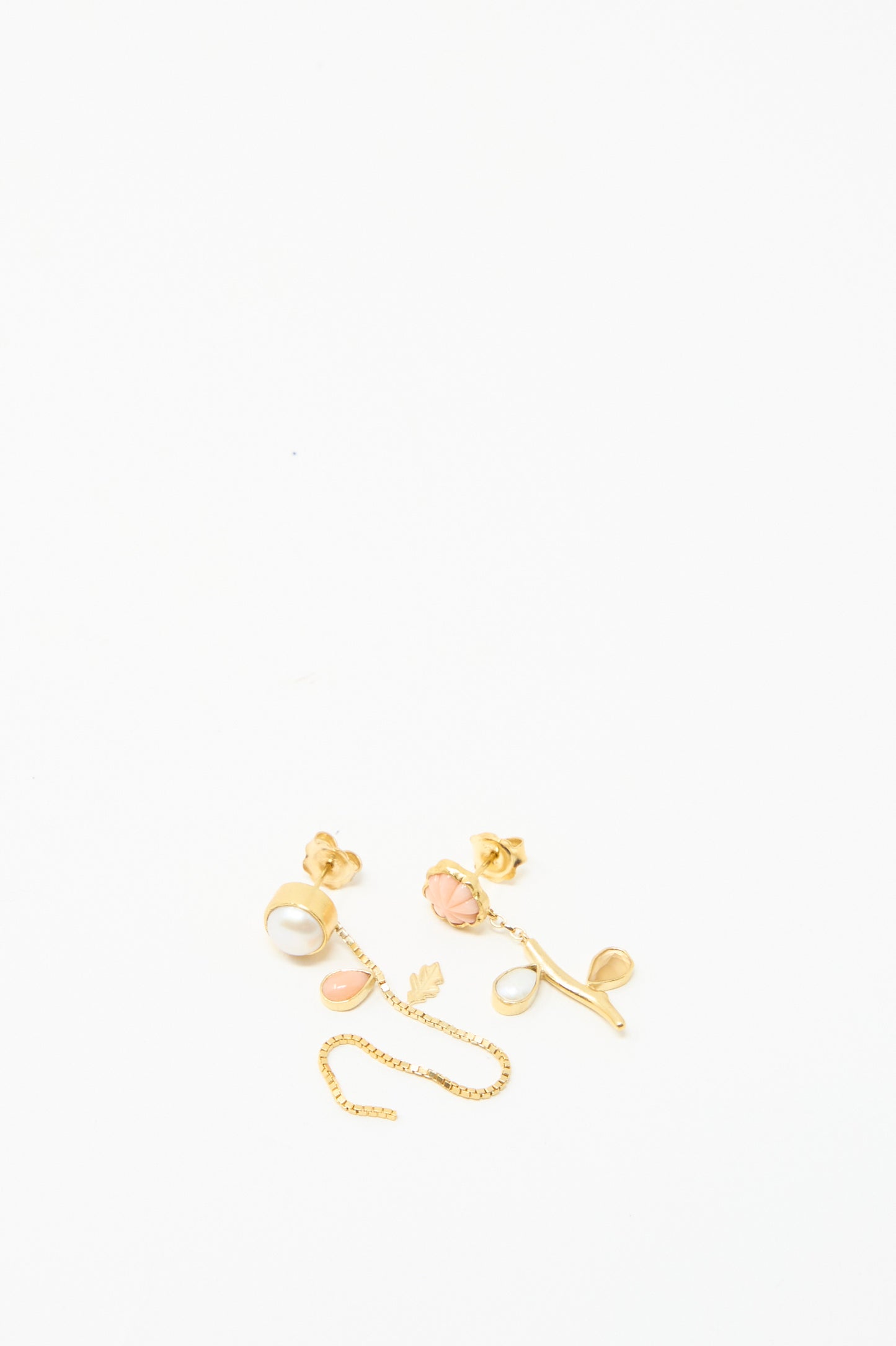 The Flower Stem and Chain Detachable Drop Earrings by Grainne Morton feature gold studs with pearl and pink rose designs, complemented by a delicate 18k gold-plated silver chain, against a white backdrop. 