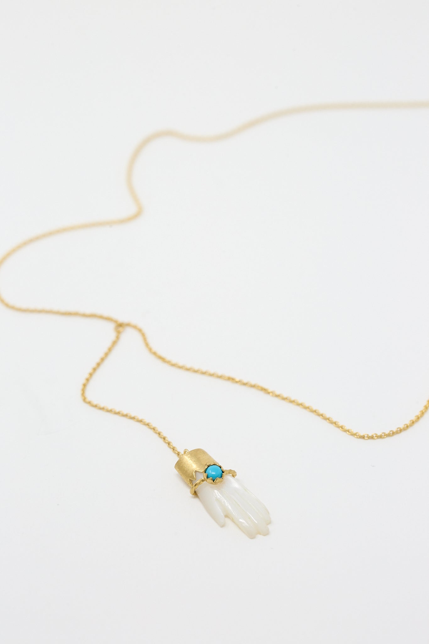 A Grainne Morton Hand Lariat with Bracelet Necklace with a Mother of Pearl stone on it.