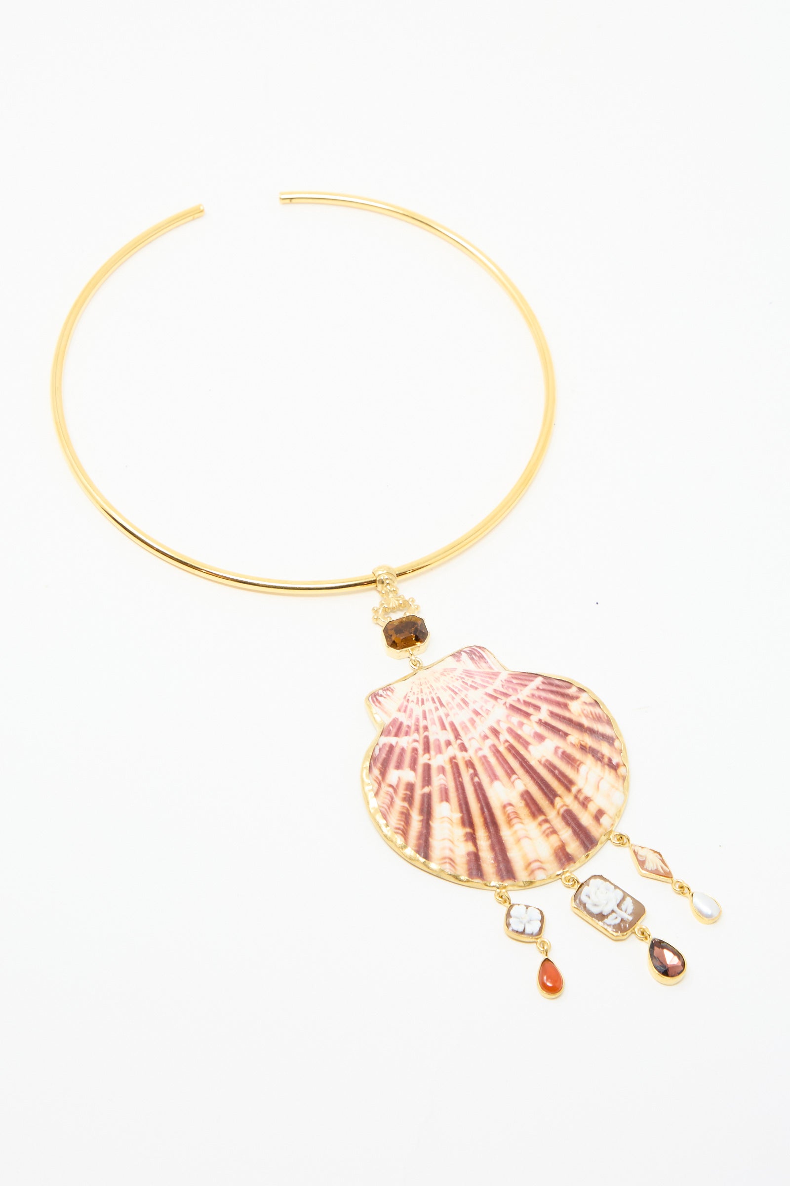 The Scallop Necklace by Grainne Morton is an 18k gold-plated silver choker with a large scallop shell pendant and dangling gemstones, against a white backdrop. 