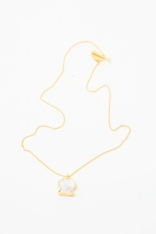 Grainne Morton's Shell Charm Necklace: a gold-plated silver chain with a shell shaped pendant, featuring a white gemstone and displayed on a white background.