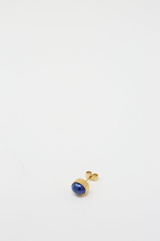 A gold-plated Grainne Morton stud earring with a blue pearl stone.