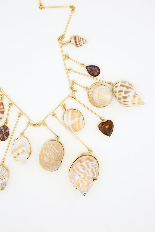 A Grainne Morton Wire Charm Drop Necklace with a variety of sea shells and Carnelian on it.