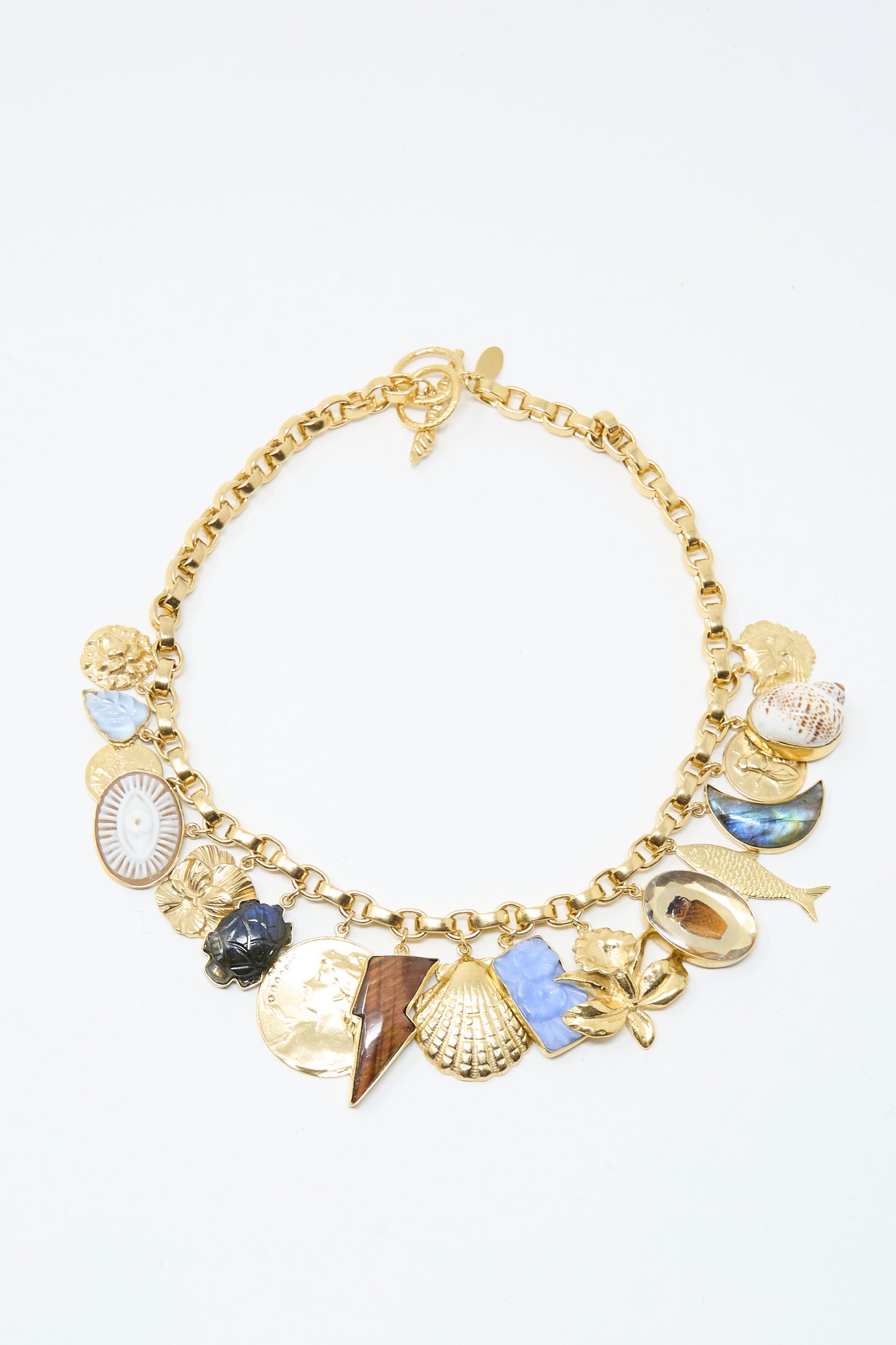 The Chunky Charm Necklace by Grainne Morton is handmade in Edinburgh, featuring assorted pendants—shells, fish, flower, lightning bolt—on an 18k gold plated silver chain.