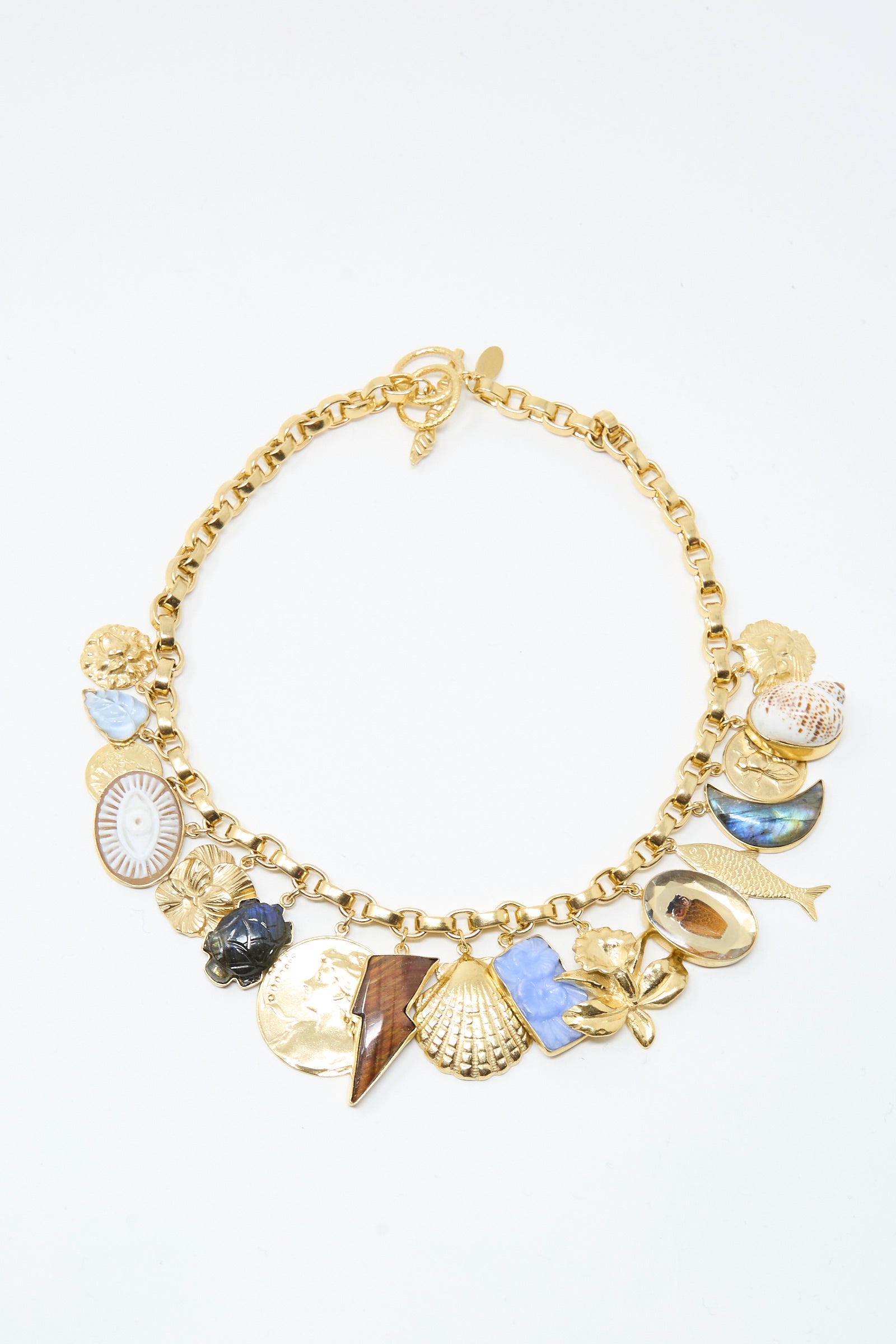 The Chunky Charm Necklace by Grainne Morton is handmade in Edinburgh, featuring assorted pendants—shells, fish, flower, lightning bolt—on an 18k gold plated silver chain.